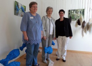 © M. Lange, 2015 Petra Weise, Christel Walter & Silke Bosbach (von li nach re) in der Premierenausstellung vor der Siegerarbeit „Forelle Blau“ von A. Siegburg